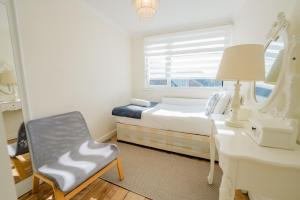 a bedroom with a bed and a desk and a chair at 3 BR House With Free Parking, Garden & Fast Wifi in Cardiff