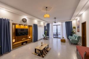 een woonkamer met een bank en een tv bij The Coastal Pearl in Karachi