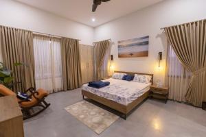 een slaapkamer met een bed in een kamer met ramen bij The Coastal Pearl in Karachi