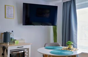 a living room with a table and a tv at Ferienwohnung Sonnengarten in Meschede