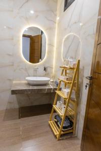 een badkamer met een wastafel en een spiegel bij The Coastal Pearl in Karachi