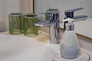 a sink with a faucet and a bottle of soap at Ferienwohnung Sonnengarten in Meschede