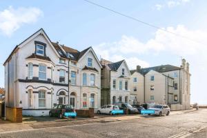 a large house with cars parked in front of it at Queens Cove with Seaviews By My Getaways in Worthing +17 photos