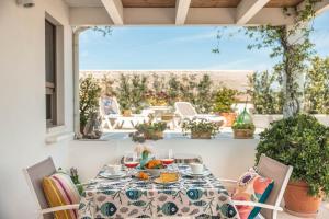 a table and chairs on a patio with a view of the ocean at MandorleOlio in Polignano a Mare