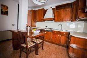 una cucina con armadi in legno e un tavolo con ciotola di Duo LUXURY SUITES a Verona Altre 4 foto