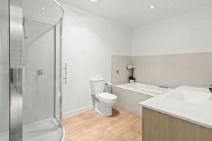 a bathroom with a toilet and a sink and a shower at Goldrush Way 4BR 3BA Lake & Mountain Views in Frankton Wharf
