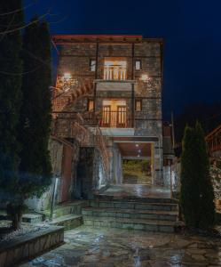 a stone house with stairs leading up to it at night at ΞΕΝΩΝΑΣ ΘΕΑ in Palaios Agios Athanasios +27 photos
