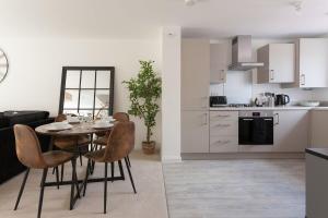 a kitchen and living room with a table and chairs at Runcorn Spacious Modern 3 bedroom House, 4 beds, On site Parking, Long stay deals in Runcorn