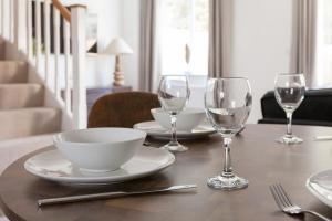 a table with plates and wine glasses on it at Runcorn Spacious Modern 3 bedroom House, 4 beds, On site Parking, Long stay deals in Runcorn