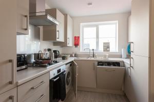 a kitchen with a sink and a stove top oven at Runcorn Spacious Modern 3 bedroom House, 4 beds, On site Parking, Long stay deals in Runcorn +35 photos