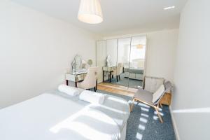 a white room with a bed and a desk and a bedroom at 3 BR House With Free Parking, Garden & Fast Wifi in Cardiff