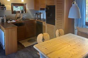 eine Küche mit einem Holztisch und einem Tisch sowie ein Esszimmer in der Unterkunft Dachferienwohnung Vieux Valais A, Ost-Mitte in Riederalp + 1 Foto