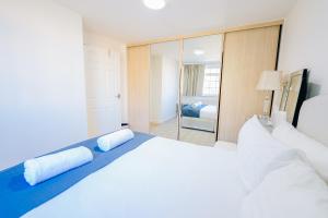 a bedroom with a large white bed and a mirror at 3 BR House With Free Parking, Garden & Fast Wifi in Cardiff +27 photos