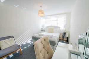 a bedroom with a bed and a chair and a couch at 3 BR House With Free Parking, Garden & Fast Wifi in Cardiff