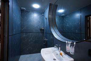 ein blaues Badezimmer mit Waschbecken und Spiegel in der Unterkunft Chehran Hotel in Samarkand