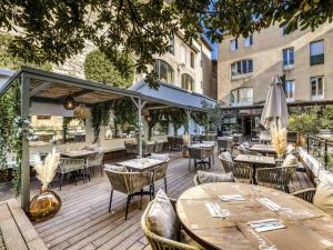 a wooden deck with tables and chairs on a building at Mercure Pont d’Avignon Centre in Avignon