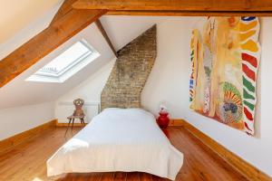 a bedroom with a bed in a attic at Jolie Maison en Bois Authentique in Dunkerque