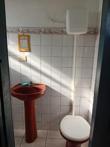 Un baño pequeño con inodoro y lavabo. en Casa Ipiranga, en Cayru