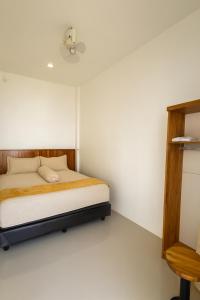 MeulabohNADA Homestay的一间卧室，里面有一张床和一个吊扇