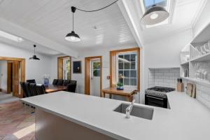 a kitchen and living room with a sink and a stove at Historic Stone Cottage Apt 1- spa - 3 min from town in Queenstown +5 photos