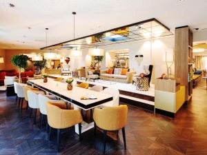 a dining room and living room with a table and chairs at Grand Hotel Bregenz - MGallery Collection in Bregenz