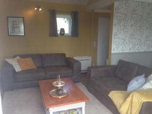a living room with two couches and a coffee table at Windekind Dh 2 in De Panne