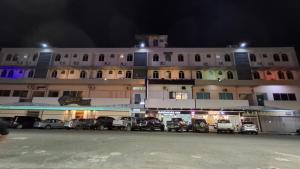 a large building with cars parked in a parking lot at Sandakan Inn in Sandakan