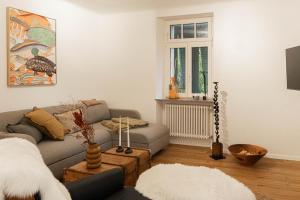 un salon avec un canapé et une fenêtre dans l'établissement Saar-Lor-Lux-Perle, à Merzig