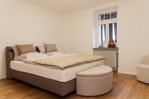 - une chambre avec un lit avec un pouf et une fenêtre dans l'établissement Saar-Lor-Lux-Perle, à Merzig
