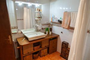 ein Badezimmer mit Waschbecken und Spiegel in der Unterkunft Cal Gironell in Santa María de Meyá