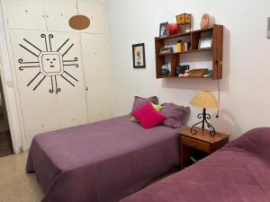a bedroom with two beds with purple sheets at Amplio 4 ambientes a la calle in Miramar