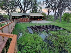 Eine Gruppe von Booten, die im Gras neben einem Gebäude liegen. in der Unterkunft Khwai Mokoro Safaris and Campsites in Khwai