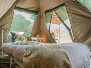ein Schlafzimmer in einem Zelt mit einem Bett darin in der Unterkunft Khwai Mokoro Safaris and Campsites in Khwai