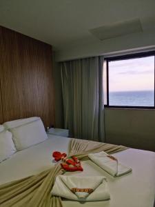 una camera d'albergo con un letto e due asciugamani di Suite Praia da Costa Confort a Vila Velha