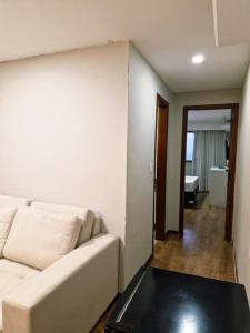 un soggiorno con un divano bianco e un tavolo di Suite Praia da Costa Confort a Vila Velha