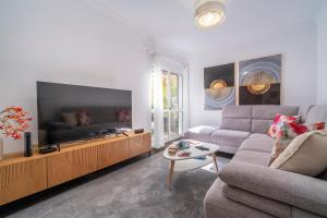 ein Wohnzimmer mit Sofa und Flachbildfernseher in der Unterkunft Lido Oasis Funchal in Funchal