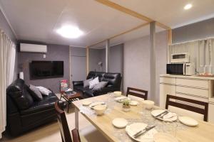 eine Küche und ein Wohnzimmer mit Tisch und Stühlen in der Unterkunft くつろぎのお宿 やわや 駅北 in Toyama