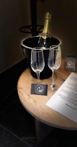 two wine glasses sitting on a table with a bucket at Le cocon de pernelle in Couvin +13 photos