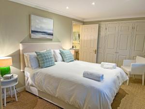 une chambre avec un grand lit blanc avec des oreillers bleus dans l'établissement Trevennen West, à St Mawes 8 autres photos