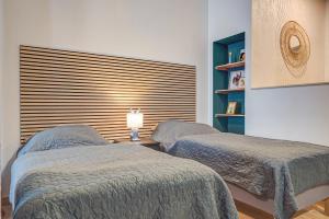 米尔豪森Apartment - Dürer Blick的一间卧室设有两张床和一扇带灯的窗户