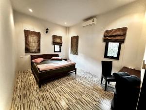 a bedroom with a bed and a chair in it at 3 bedroom villa with swimming pool Lamai in Nathon Bay
