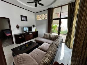 a living room with a couch and a tv at 3 bedroom villa with swimming pool Lamai in Nathon Bay