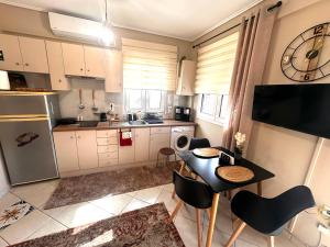 a kitchen with a table and chairs and a kitchen with a clock at Argiro's apartment in Mytilene