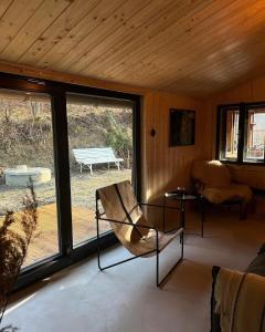 ヴェルケー・カルロヴィツェにあるChata u studánkyのポーチに椅子とベンチがあるリビングルーム