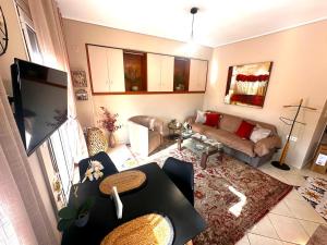 a living room with a couch and a tv at Argiro's apartment in Mytilene