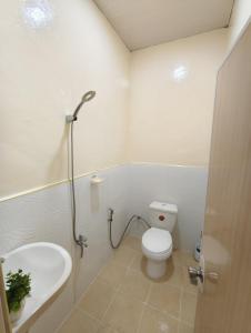 une salle de bains avec toilettes et lavabo dans l'établissement Loreto's Inn, à Polomolok