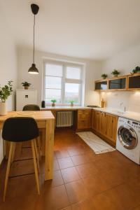 a kitchen with a table and a washing machine at Budovatelska Apartment in Bratislava
