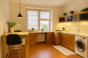 a kitchen with a table and a washing machine at Budovatelska Apartment in Bratislava