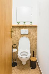 a bathroom with a white toilet with a window at Budovatelska Apartment in Bratislava +6 photos