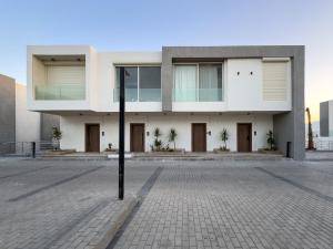 a large white building on a street at Poolside Townhome with 2 Masters, a Huge Terrace in El Gouna in Hurghada